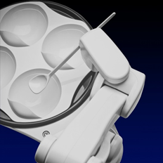 White plastic robotic arm with spoon poised over an attached plate containing four sections.  Top view.